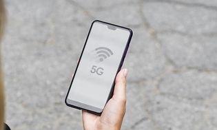 5G - Nainen katsoo 5G-älypuhelintaan