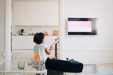Pieni tyttö ohjaa televisiota kaukosäätimellä
