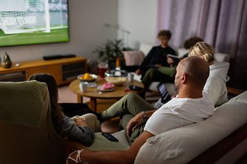 Family in sofa watching sports on TV