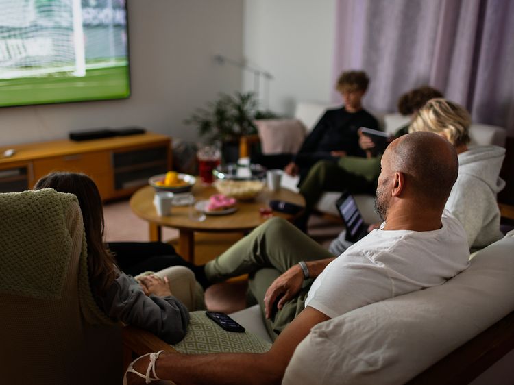 Family in sofa watching sports on TV