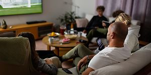 Family in sofa watching sports on TV