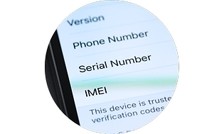 Puhelin, jonka näytöllä näkyy IMEI-numero