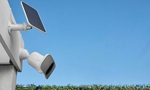 Arlo Pro 3 Floodlight-kamera talon katolla, aurinkopaneelin vieressä