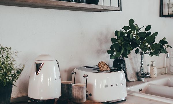 Valkoinen Smeg-leivänpaahdin keittiön työtasolla yhdessä valkoisen teekeittimen kanssa