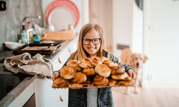 Tyttö, joka pitelee korvapuustitarjotinta