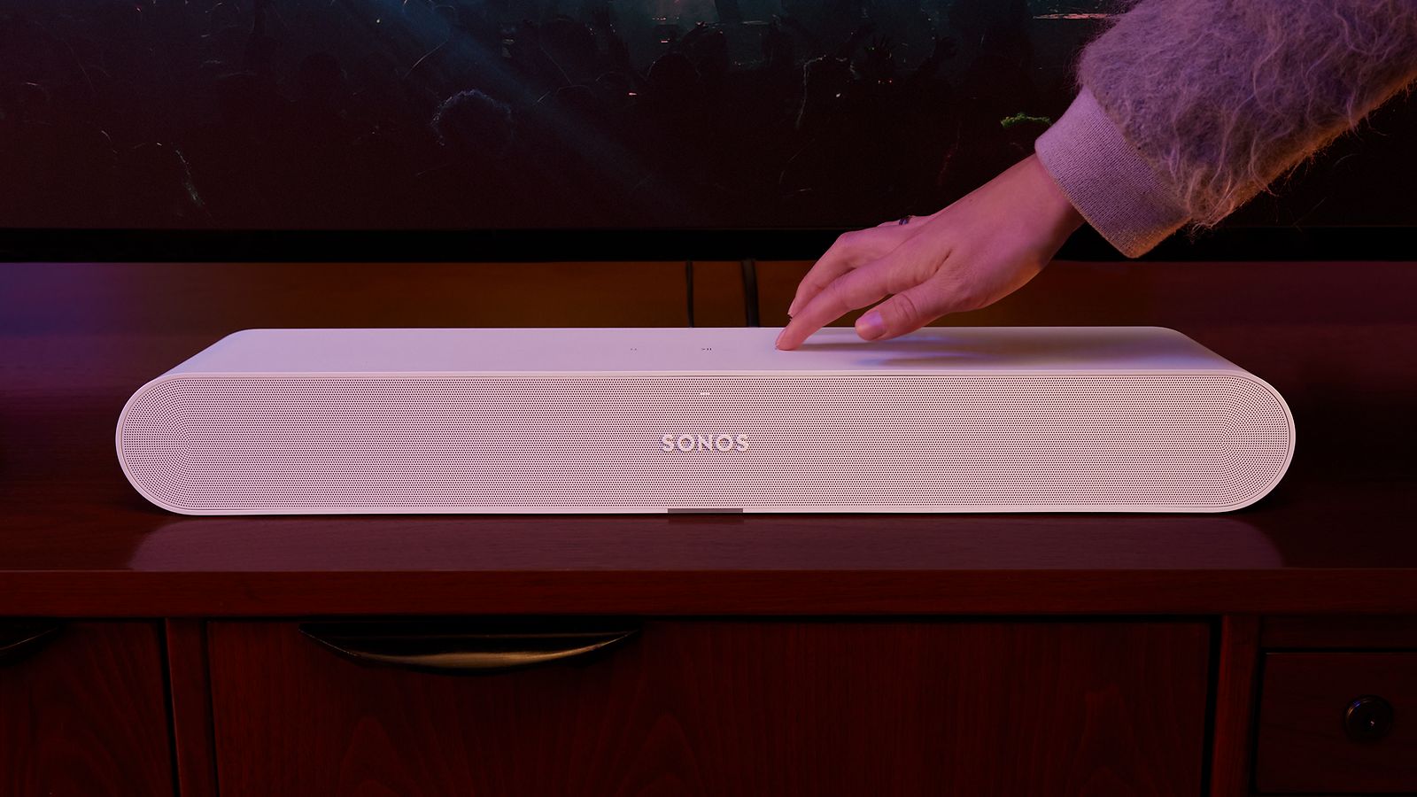 Sonos-Käsi painaa valkoisen Ray soundbarin painiketta
