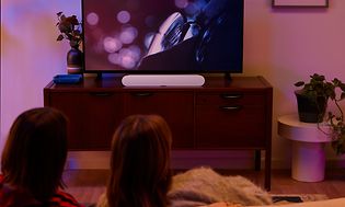 Pariskunta katselee televisiota pimeässä