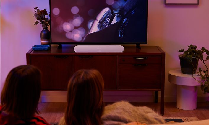 Pariskunta katselee televisiota pimeässä