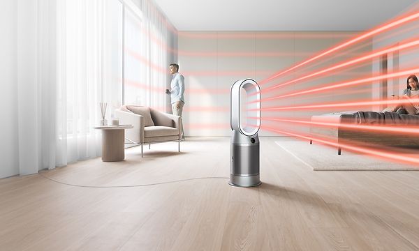 Dyson-ilmanpuhdistin tuottaa kuumailmavirtauksia olohuoneeseen, jossa on seisova mies 