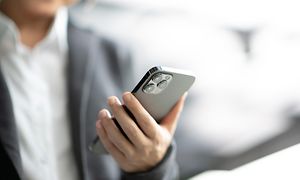 Älypuhelin - Lähikuva liikenaisesta, jolla on musta iPhone 12 Pro Max -älypuhelin