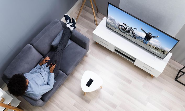 Sohvalla istuva mies katsoo televisiota