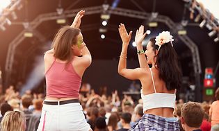 Tytöt konsertissa ihmisjoukon keskellä