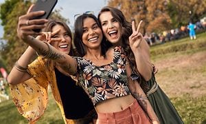 Kolme tyttöä ottamassa selfiekuvaa itsestään älypuhelimella