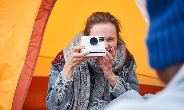 Nainen ottamassa kuvaa Polaroid-kameralla