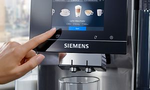 Sormi painamassa helppokäyttöistä Siemens EQ700 -espressokoneen ohjauspaneelin kosketusnäyttöä