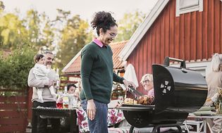 Kesä - Tyttö seisoo grillin vieressä