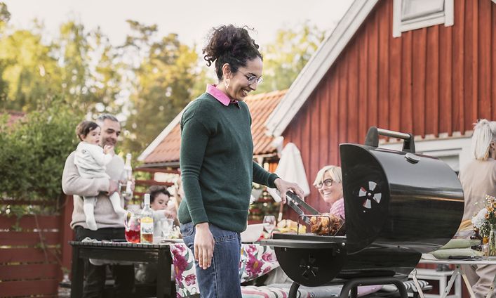 Kesä - Tyttö seisoo grillin vieressä