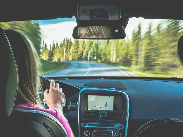 Nainen ajaa autoa, jossa on GPS-navigaattori