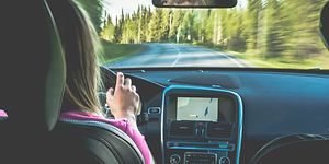 Nainen ajaa autoa, jossa on GPS-navigaattori