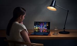 Nainen työskentelee pöydällä olevalla ZenBook 14 OLED -kannettavalla