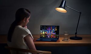 Nainen työskentelee pöydällä olevalla ZenBook 14 OLED -kannettavalla
