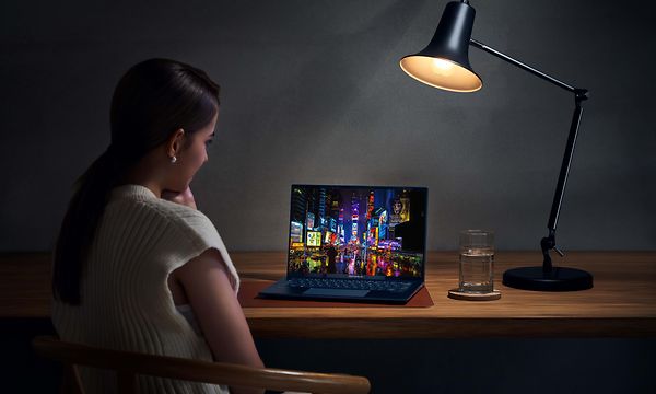 Nainen työskentelee pöydällä olevalla ZenBook 14 OLED -kannettavalla