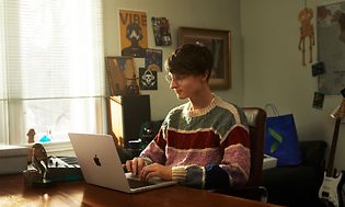 Nuori poika työskentelee MacBook Pro -kannettavallaan, jossa on M1-siru