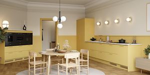 Keltainen Trend Mellow -keittiö avokeittiöratkaisulla ja ruokailuryhmä pyöreällä pöydällä keskellä keittiötä