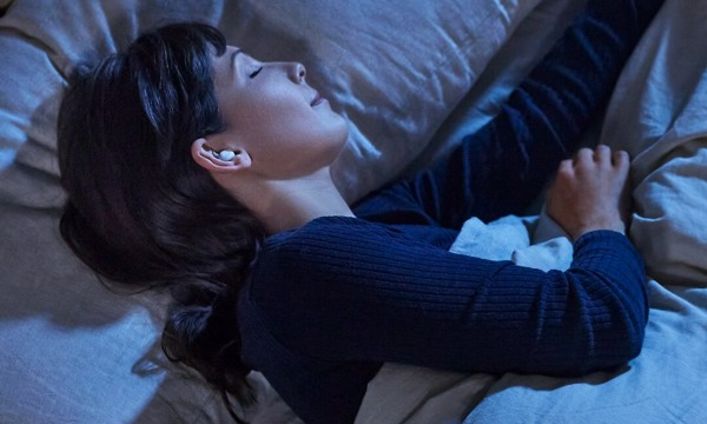 Nainen nukkuu Bose sleepbuds -kuulokkeet korvissaan