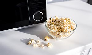 MIkroaaltouunit - MIkroaaltouuni sekä kulhollinen popcornia sen vieressä