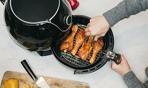 Airfryer-laitteet - Airfryer-kiertoilmakypsennin kypsentämässä kanaa