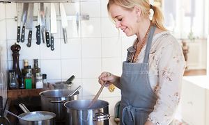 SDA - Ruoanlaitto - Nainen valmistaa päivällistä keittiössä