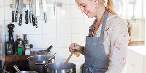 SDA - Ruoanlaitto - Nainen valmistaa päivällistä keittiössä