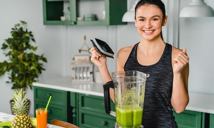 Nainen valmistaa terveellistä smoothiejuomaa tehosekoittimella
