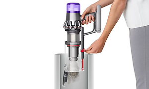 Nainen tyhjentää Dyson V11 -imurin pölysäiliötä