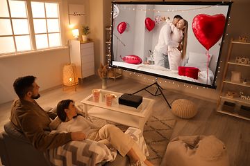 TV - Pariskunta istuu suurikokoisen television edessä