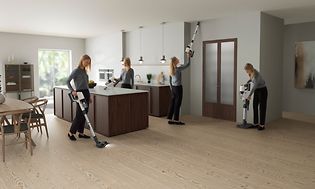 Electrolux- Siivous -Nainen käyttää Electroluxin varsi-imuria asunnon siivoamiseen