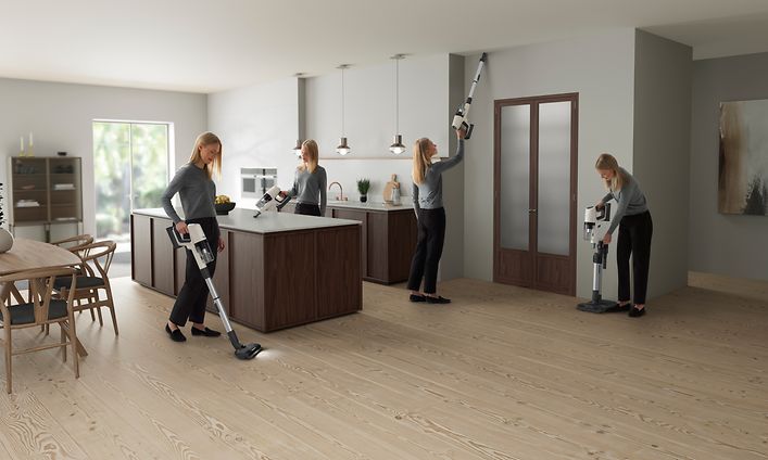 Nainen käyttää Electroluxin varsi-imuria asunnon siivoamiseen