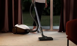Nainen käyttää Electrolux Pure 9 -pölynimuria imuroimiseenm cleaner