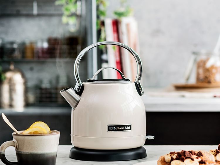 Valkoinen KitchenAid-vedenkeitin pöydällä