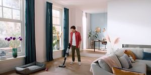 Mies siivoaa Philips AquaTrio -imurilla.