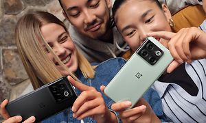Kolme ystävystä katsovat yhdessä OnePlus 10T -älypuhelinta