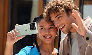 Tyttö ja poika ottavat selfietä OnePlus 10T -älypuhelimella