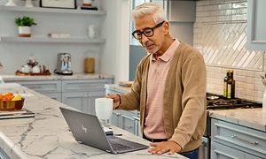 Google - Chromebook - mies pitelee kahvikuppia HP 14 Chromebookin ääressä