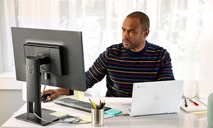 Google - Chromebook - mies tekee töitä HP-elitellä työpöytänsä ääressä ja katsoo näyttöä