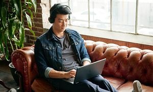 Google - Chromebook - mies istuu sohvalla HP X360 Chromebookin kanssa