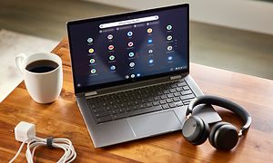 Google - Chromebook - Acer Spin pöydällä näyttö esillä kahvikupin ja kuulokkeiden vieressä