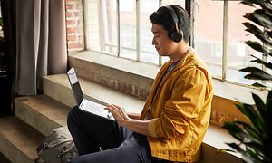 Google - Chromebook - mies istuu ikkunan ääressä HP X360 Chromebookin kanssa