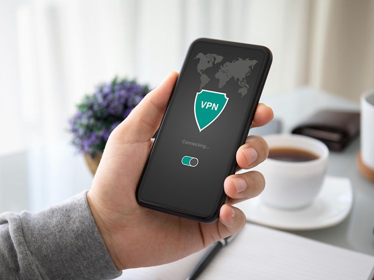 Käsi pitelee puhelinta, jonka ruudulla on VPN-logo