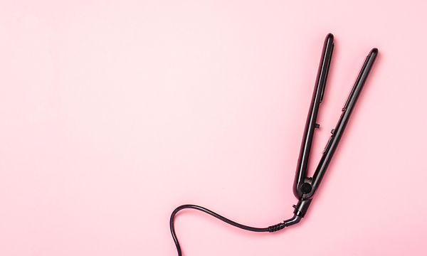 Suoristusrauta pinkkiä taustaa vasten